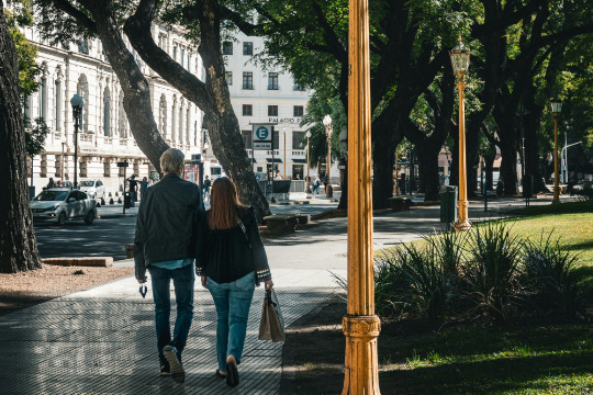 Paar spaziert entlang einer schönen Allee mit Bäumen in Buenos Aires