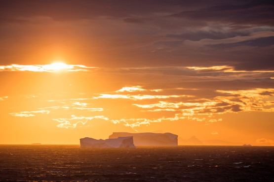 Eisberge im offenen Meer bei Sonnenuntergang