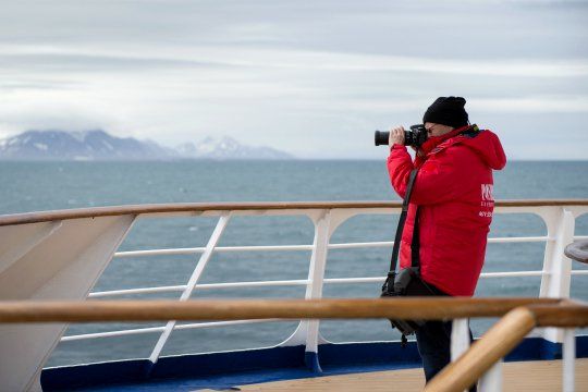 Gast der Expedition mit seiner Kamera an Bord des Kreuzfahrtschiffs