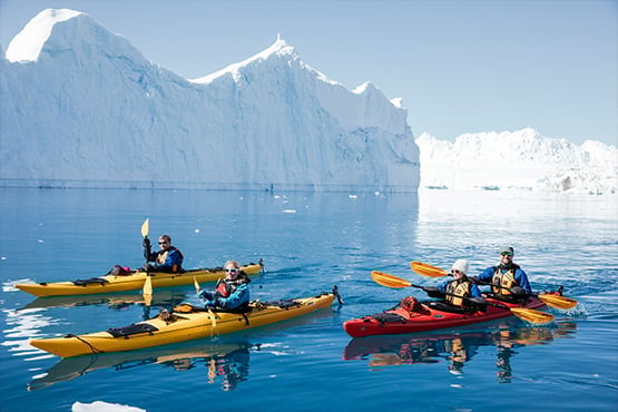 Kayakfahren als Firmenevent in der Arktis oder Antarktis. Ein unvergessliches Erlebniss erleben diese Kayaker beim paddeln durch die eisige Landschaft.