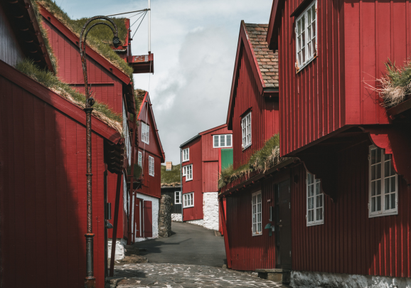 Tinganes mit seine roten Holzhäuser, die historische Halbinsel und das Verwaltungszentrum in Tórshavn, der Hauptstadt der Färöer-Inseln besuchen wir gerne auf unseren Kreuzfahrten
