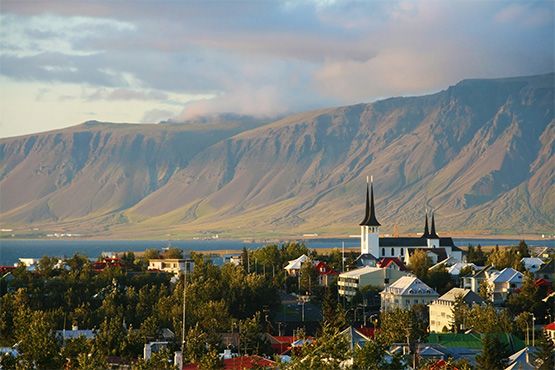 Reykjavík auf Island mit steilen Bergen und dem Meer im Hintergrund