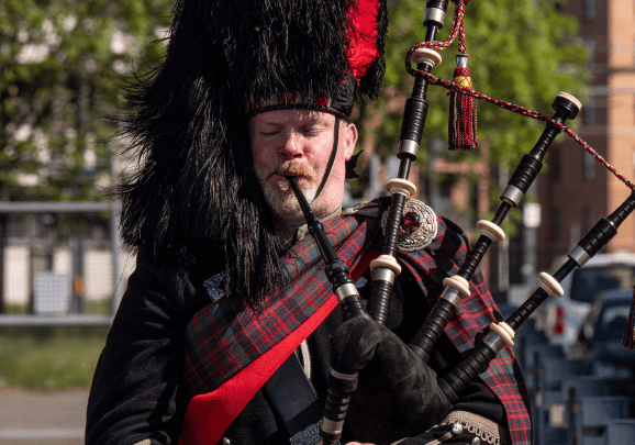 Mann in schottischer Kleidung spielt Dudelsack in Edinburgh.