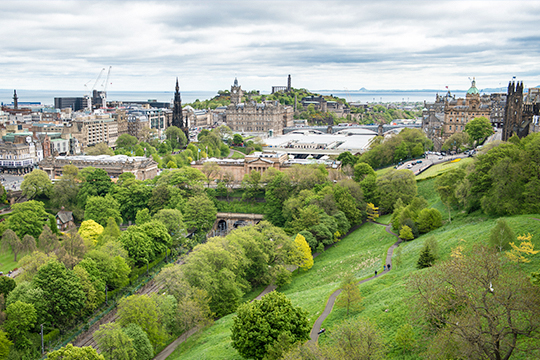 Blick über Parkanlagen und Häuser der Stadt Edinburgh