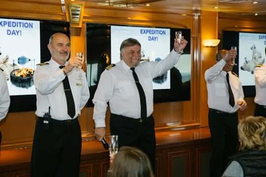 Die Crew vom Kreuzfahrtschiff prostet den Gästen zu
