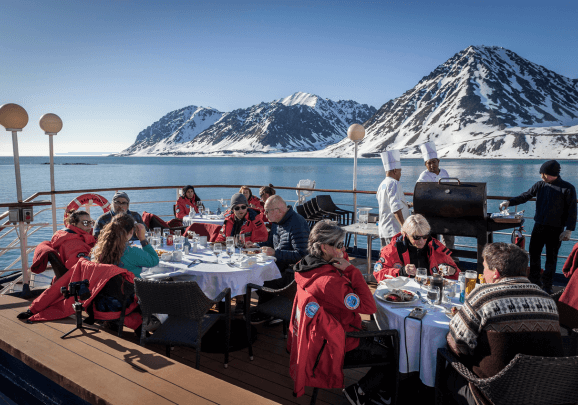 Mittagessen an Deck des Expeditionsschiffs während der Spitzbergen Kreuzfahrt bei strahlender Sonne und ruhiger See