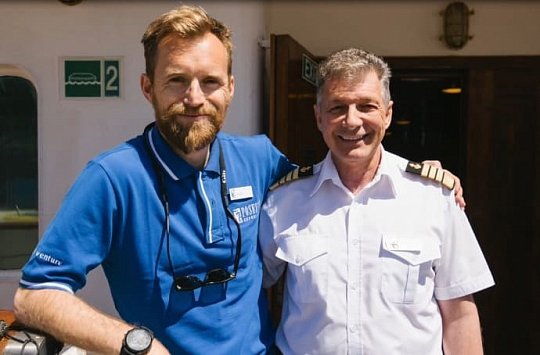 Der Expeditionsleiter mit einem Crewmitglied vom Expeditionskreuzfahrtschiff im Hafen von Portsmouth in England