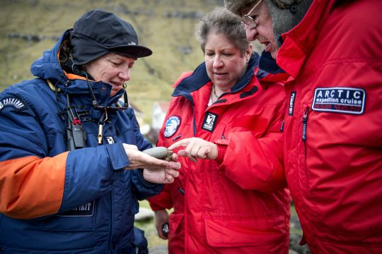 ein Expeditionsmitglied erklärt den Kreuzfahrtgästen etwas zu den Gesteinsarten