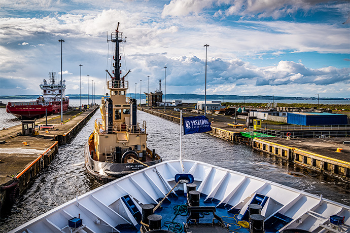 Das Expeditionsschiff von Poseidon Expeditions wird mit dem Schlepper in Hafen von Leith (Edinburgh), Schottland manövriert