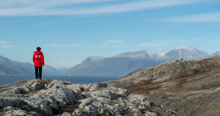Nordost-Grönland Nationalpakt und ein Expeditionsmitglied in karger Landschaft von hinten 02_Ella-Island_03_DSC8504_Anthony-Smith
