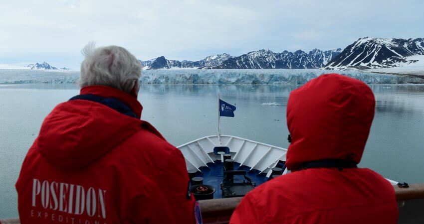 Passagiere einer Polarkreuzfahrt von Poseidon Expeditions betrachten vom Deck des Schiffs einen Gletscher svalbard-2