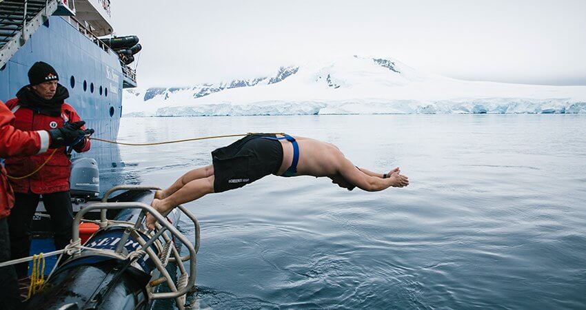 Ein Mann springt ins eiskalte Polarmeer, der Klassiker Polarplunge ice-polar-plunge