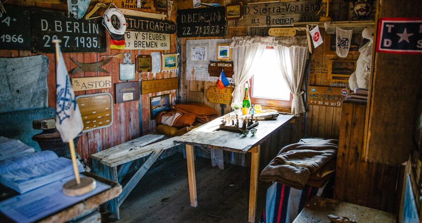 Das Lloyds Hotels, eine historisch, rustikale Hütte im Möllerfjord auf Spitzbergen. Das Innere ist mit zahlreichen Gedenktafeln und Erinnerungsstücken geschmückt. Die Hütte diente seit dem frühen 20. Jahrhundert als Orientierungspunkt für Arktisreisende und Kreuzfahrtschiffe und bot einen geschützten Platz im Fjord. Eine-Frau-erlebt-die-Polarnacht_02