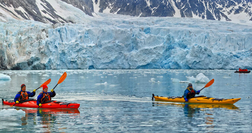 Ein Expeditions-Kajak-Moment, wahrscheinlich in der Nähe des Monacobreen-Gletschers auf Spitzbergen oder einer ähnlichen arktischen Region, der ein hautnahes Erlebnis der eisigen Landschaft bietet. svalbard-3